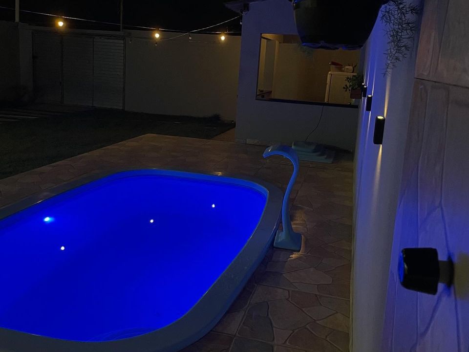 A cascata derramando na piscina acesa em azul